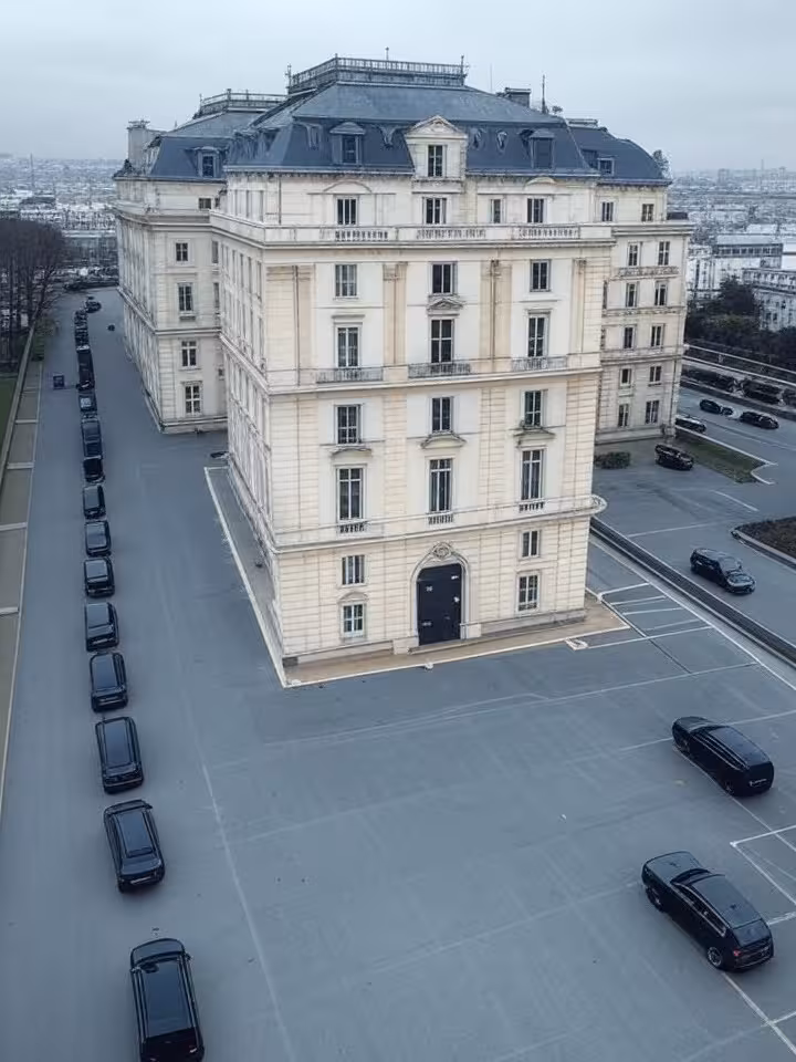 Aerial view of luxury European hotel with security cordon and black vehicles, mysterious elite gathe