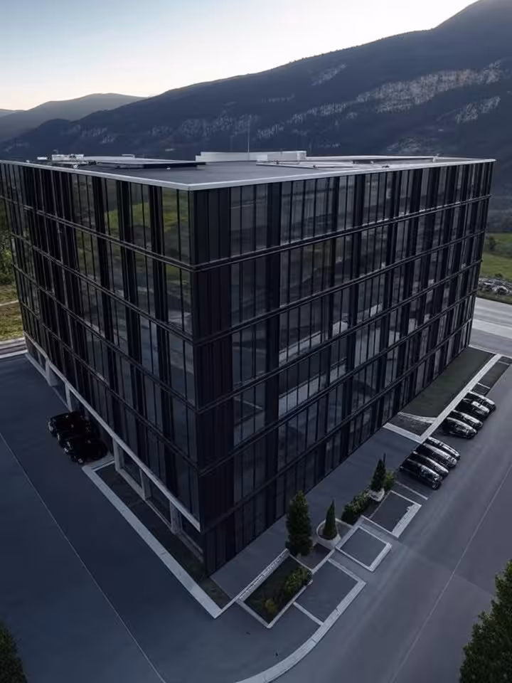 Aerial view of luxury European conference hotel surrounded by mountains, high-security perimeter, bl
