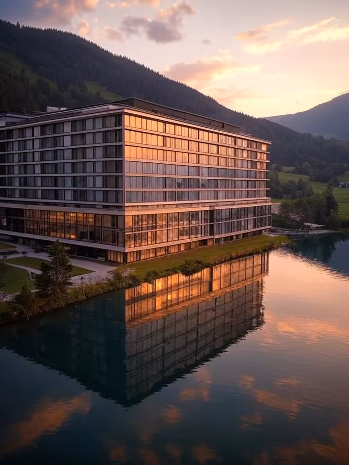 Aerial view of luxury lakeside resort hotel surrounded by security perimeter, mountainous European l